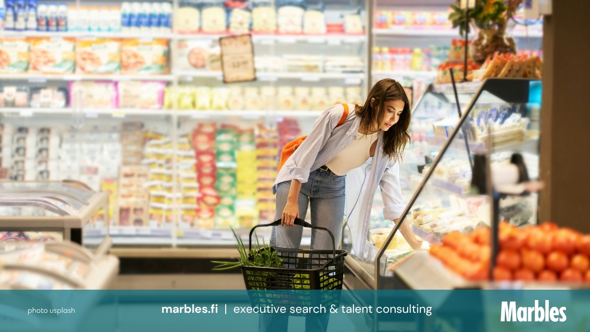 Asiakas ostoksilla ruokakaupassa diginäyttöjen ja in-store median keskellä